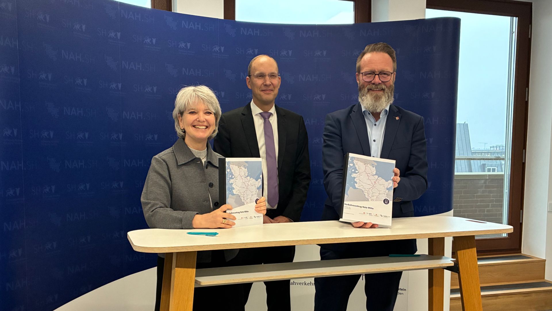 Nicole Berlin, Vorsitzende der Regionalleitung von DB Regio Nord, und Verkehrsminister Claus Ruhe Madsen unterschreiben im Beisein von NAH.SH-Geschäftsführer Dr. Arne Beck (Foto Mitte) den Verkehrsvertrag für das Bahnnetz Mitte. Copyright: NAH.SH GmbH